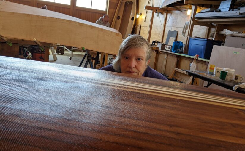 Janell is looking over the top of the cedar strip canoe